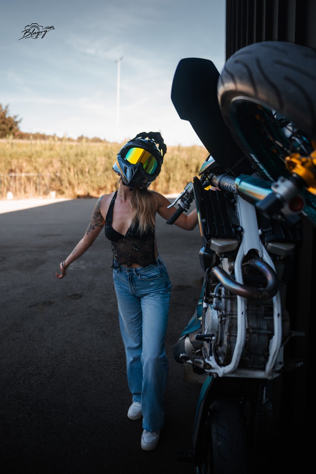En jean à côté de la moto dressée